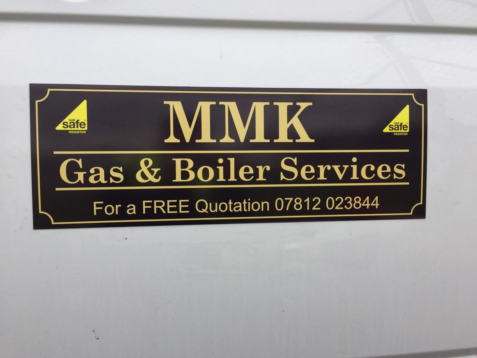 MMK Gas and Boiler Services sticker in gold on black: For a FREE Quotation 07812 023844, with Gas Safe Register marks