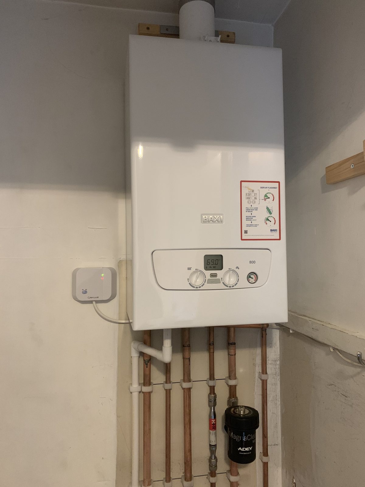 Boiler with its controls, copper pipework and a magnetic filter below