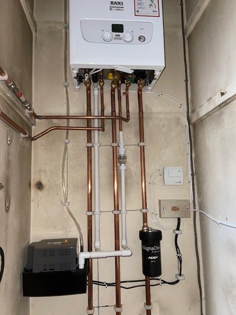 Copper pipework and a magnetic filter running down from a boiler